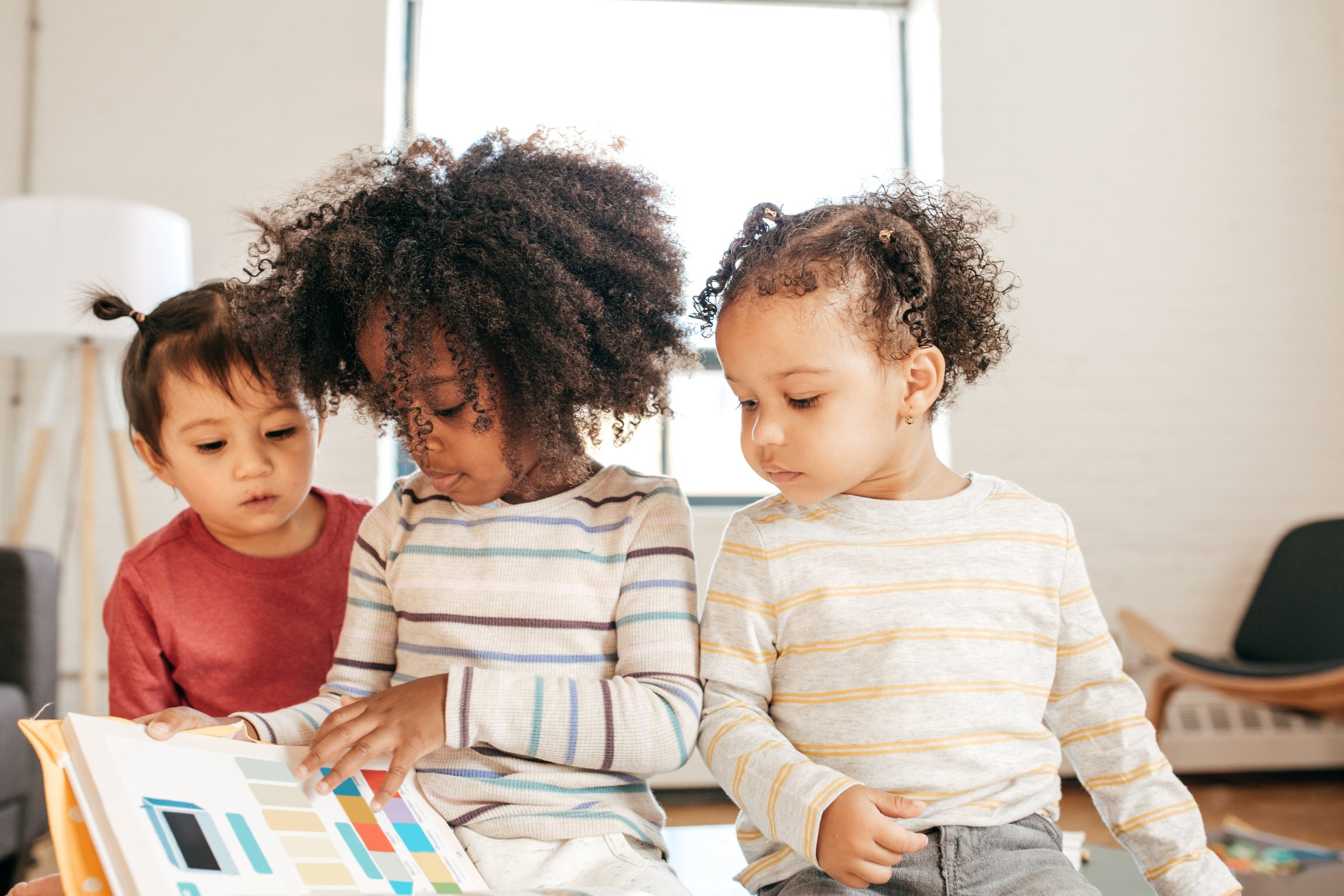 Three kids in daycare with book